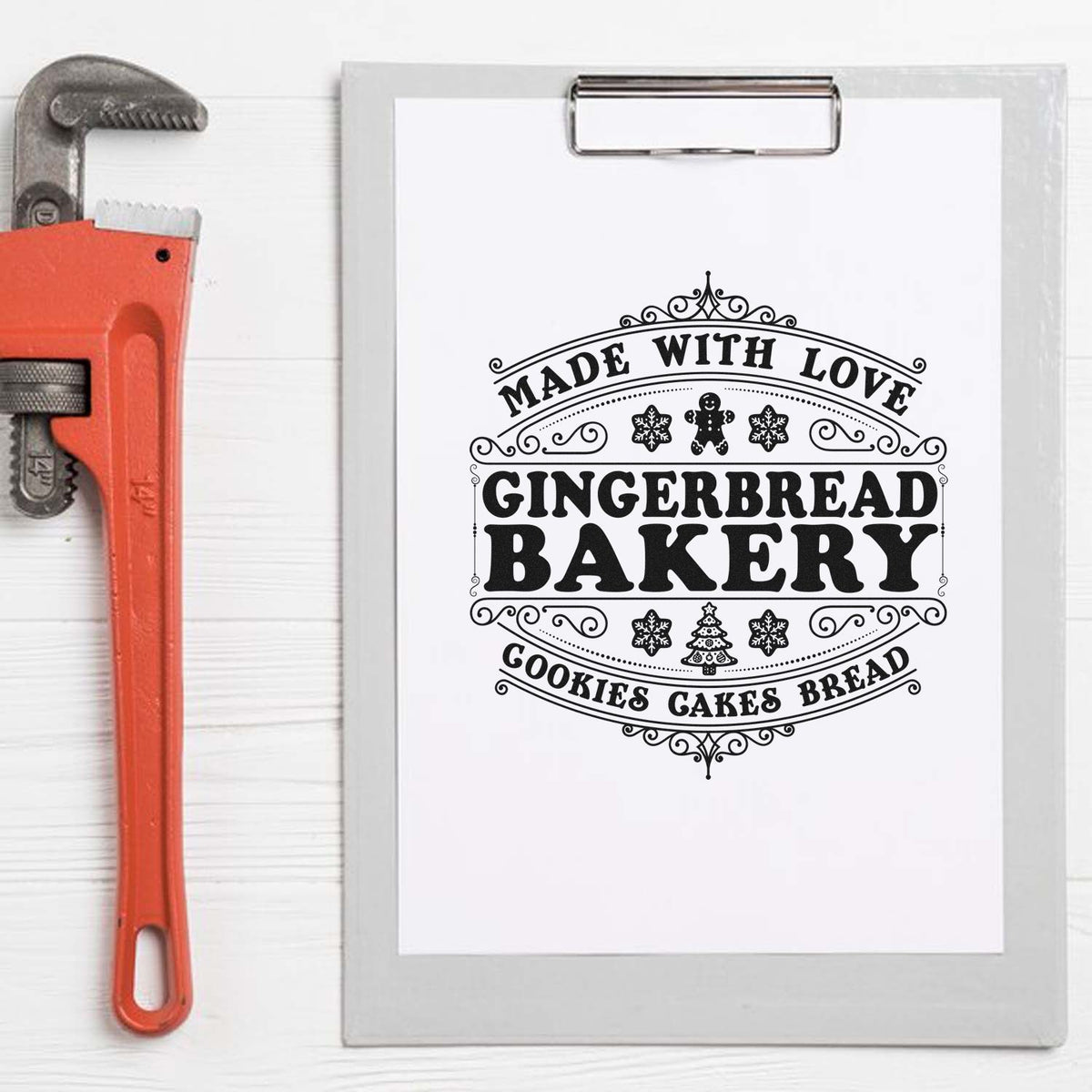 Red pipe wrench beside clipboard with black gingerbread bakery stamp seal reading Made with Love, Cookies, Cakes, Bread.