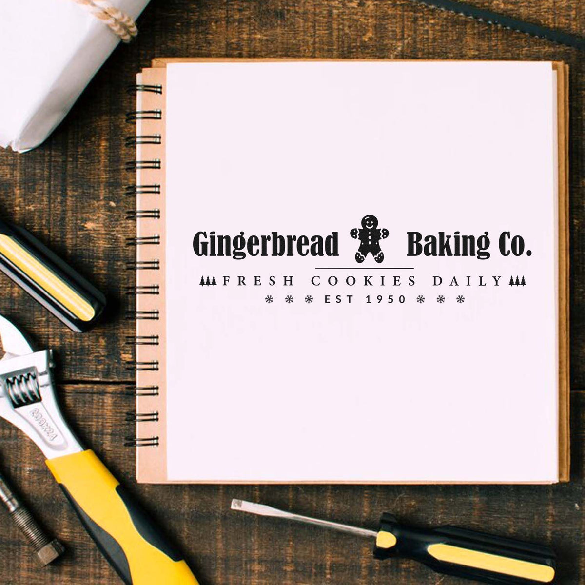 Custom black stamp and seal for Gingerbread Baking Co. with gingerbread man, Fresh Cookies Daily, on a white notebook page.