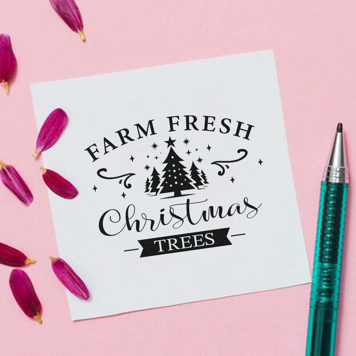Black Farm Fresh Christmas Trees stamp seal on white card, with pine trees and stars, on pink background with purple petals.