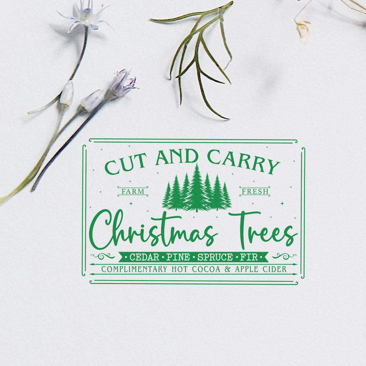 Green Christmas tree stamp and seal with pine trees and floral accents, reading Cut and Carry Christmas Trees on white.