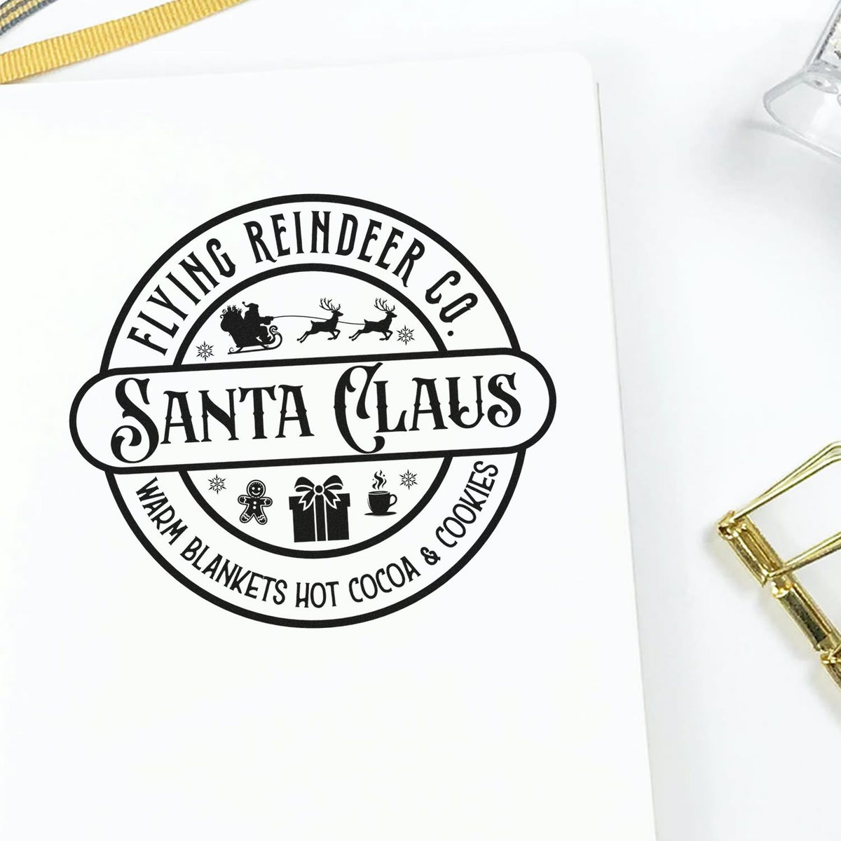 Black Santa Claus Flying Reindeer Co. custom stamp seal on white paper with gift, gingerbread, cocoa and winter icons.