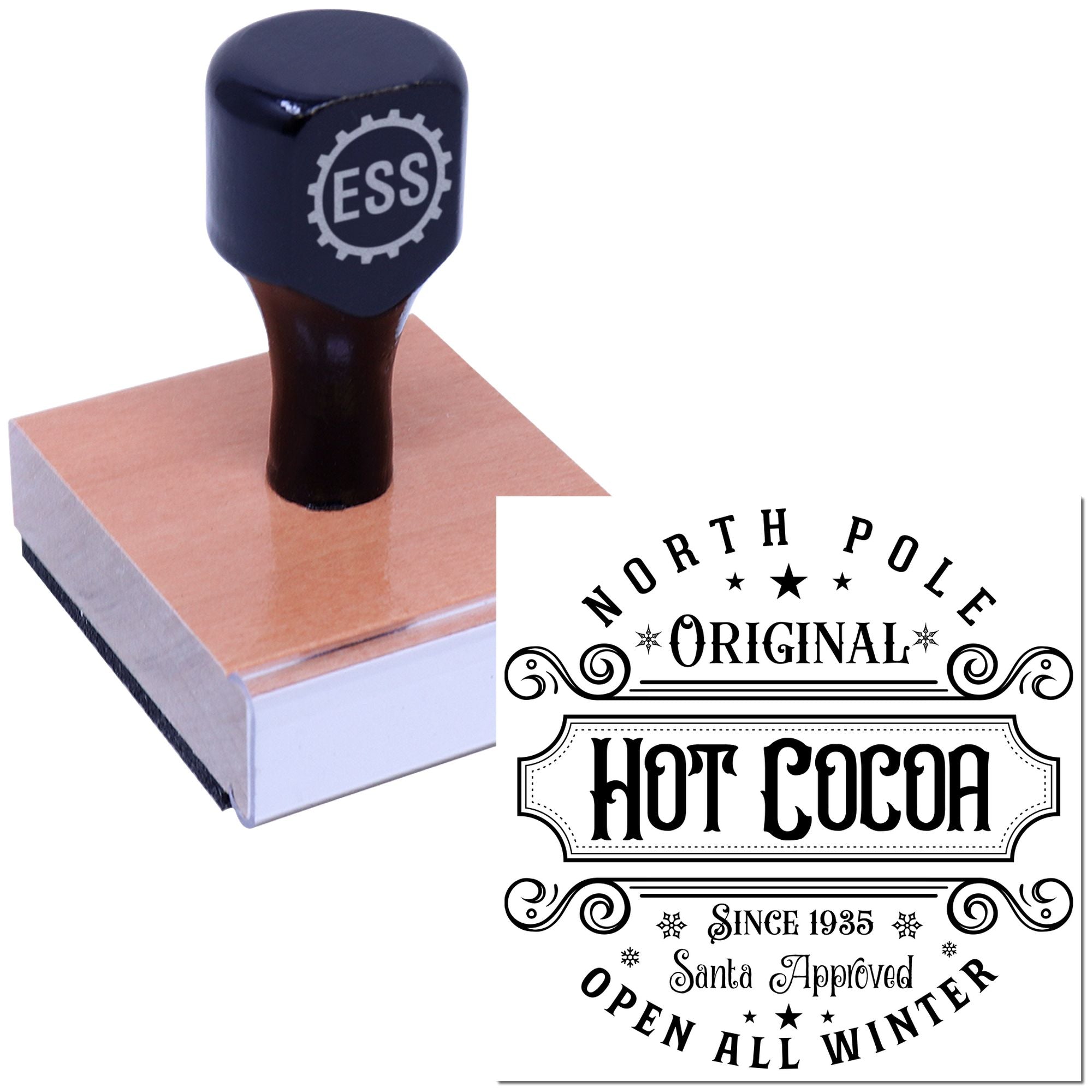 Dark navy ESS rubber stamp on a pink pad beside a black-and-white holiday seal reading North Pole Original Hot Cocoa