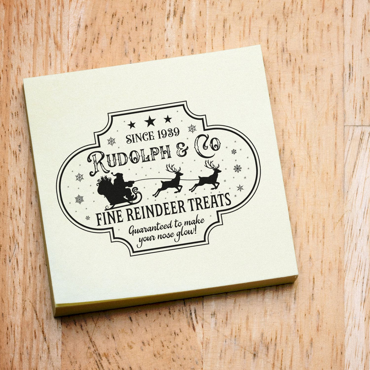 Cream stamp-and-seal box with black vintage Rudolph & Co reindeer treats label, Santa sleigh and reindeer on wood.