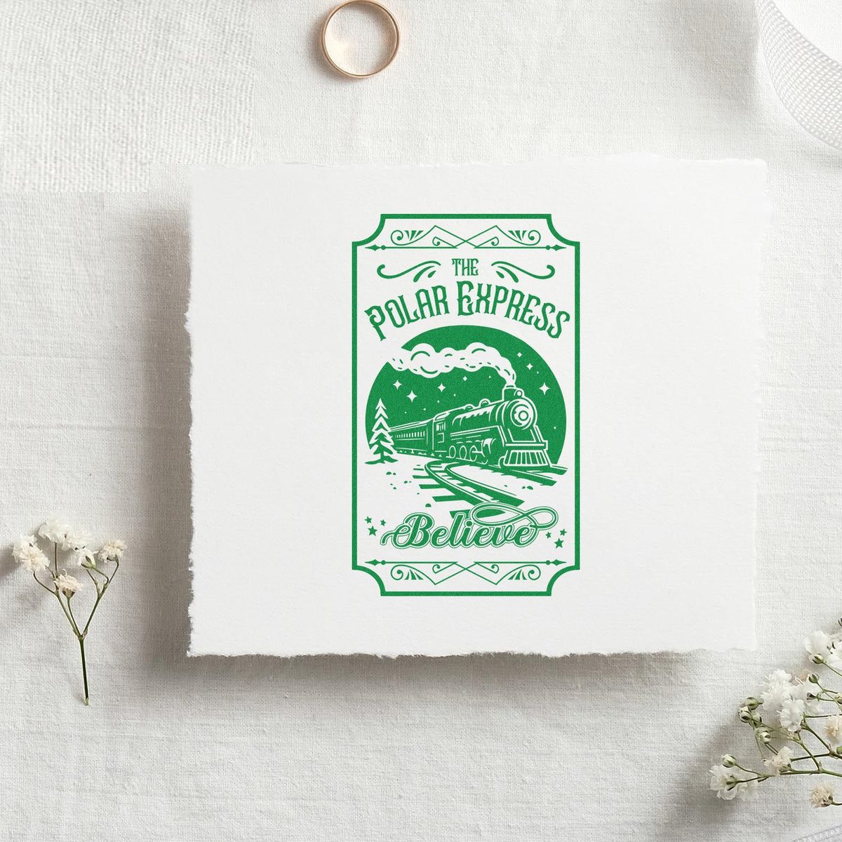 Green vintage stamp and seal design with a steam train and The Polar Express Believe on white handmade paper.