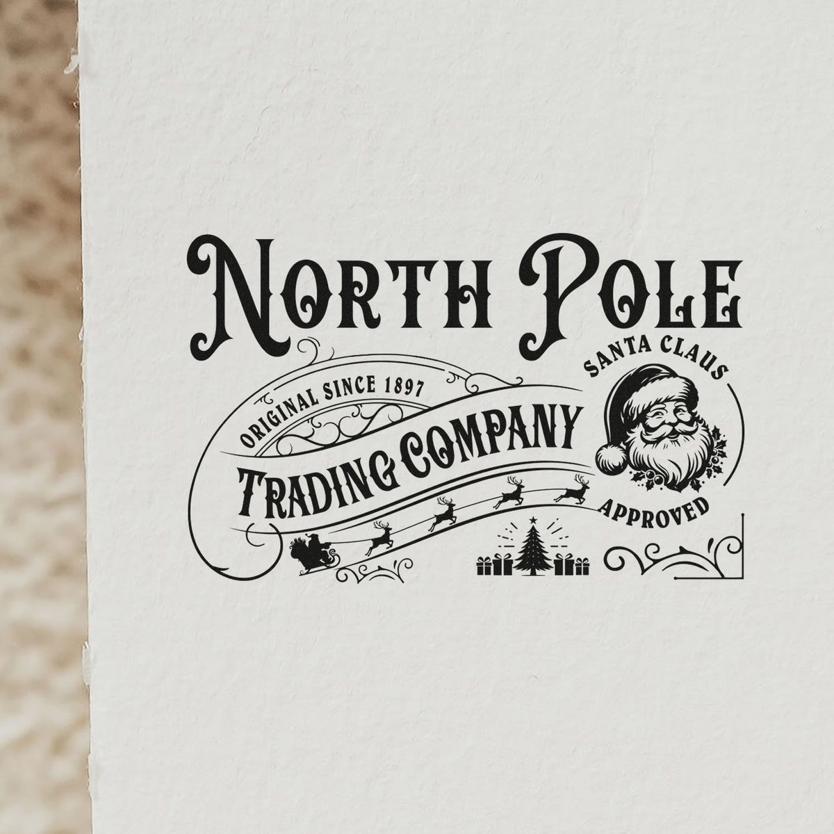 Black North Pole Santa Claus approved vintage stamp seal design with reindeer, sleigh, tree and trading company text on white paper.