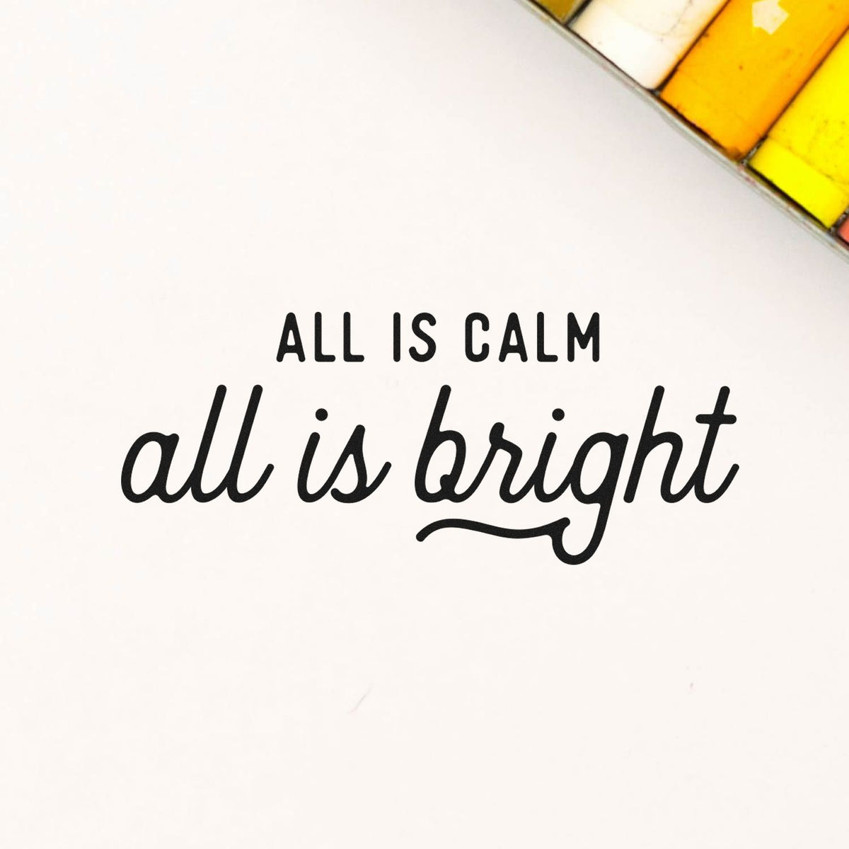 Black custom stamp seal reading All is calm, all is bright on white, with a yellow-orange stained glass corner.
