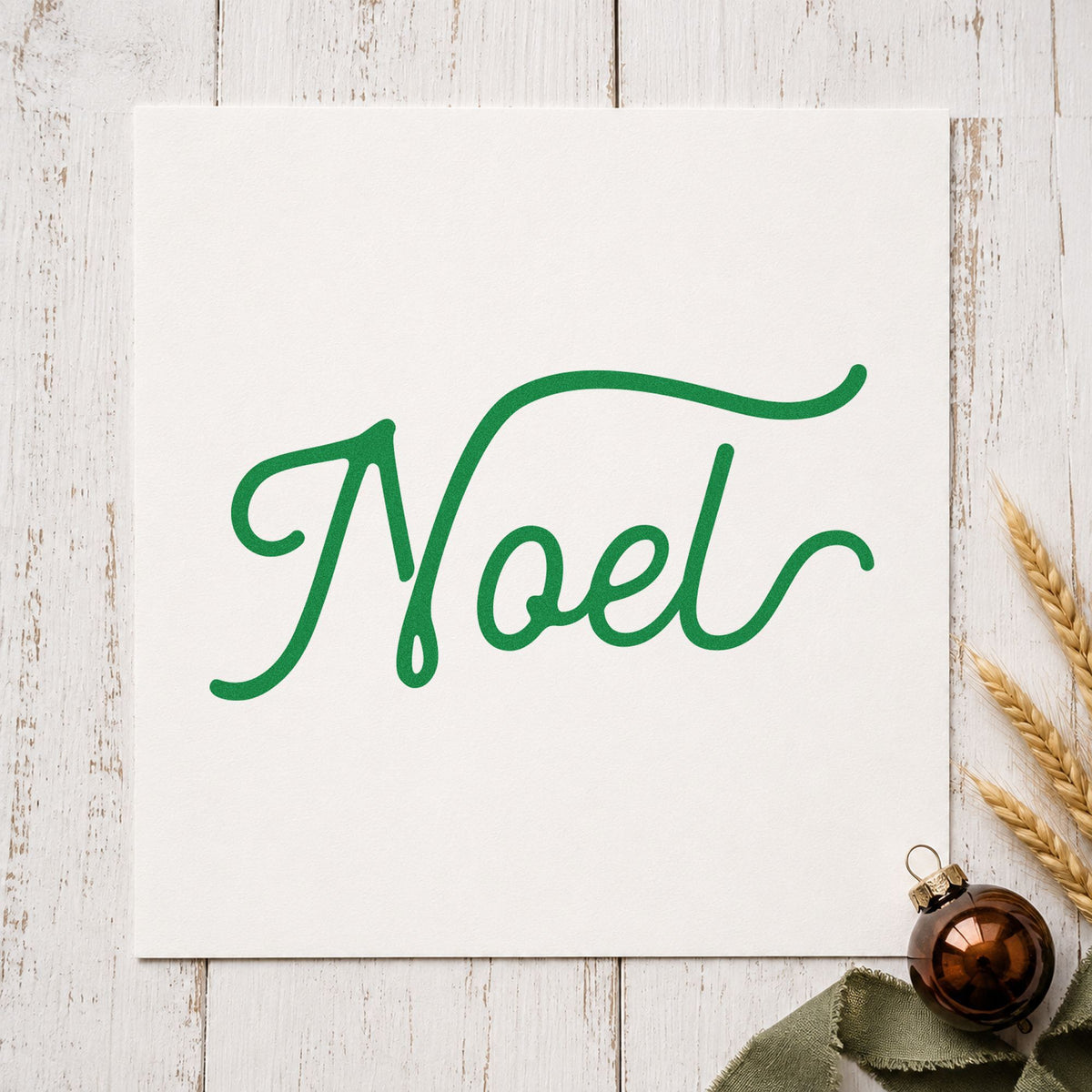 Noel Flowing Script craft stamp in green ink on cardstock, an easy option for wide spread album.