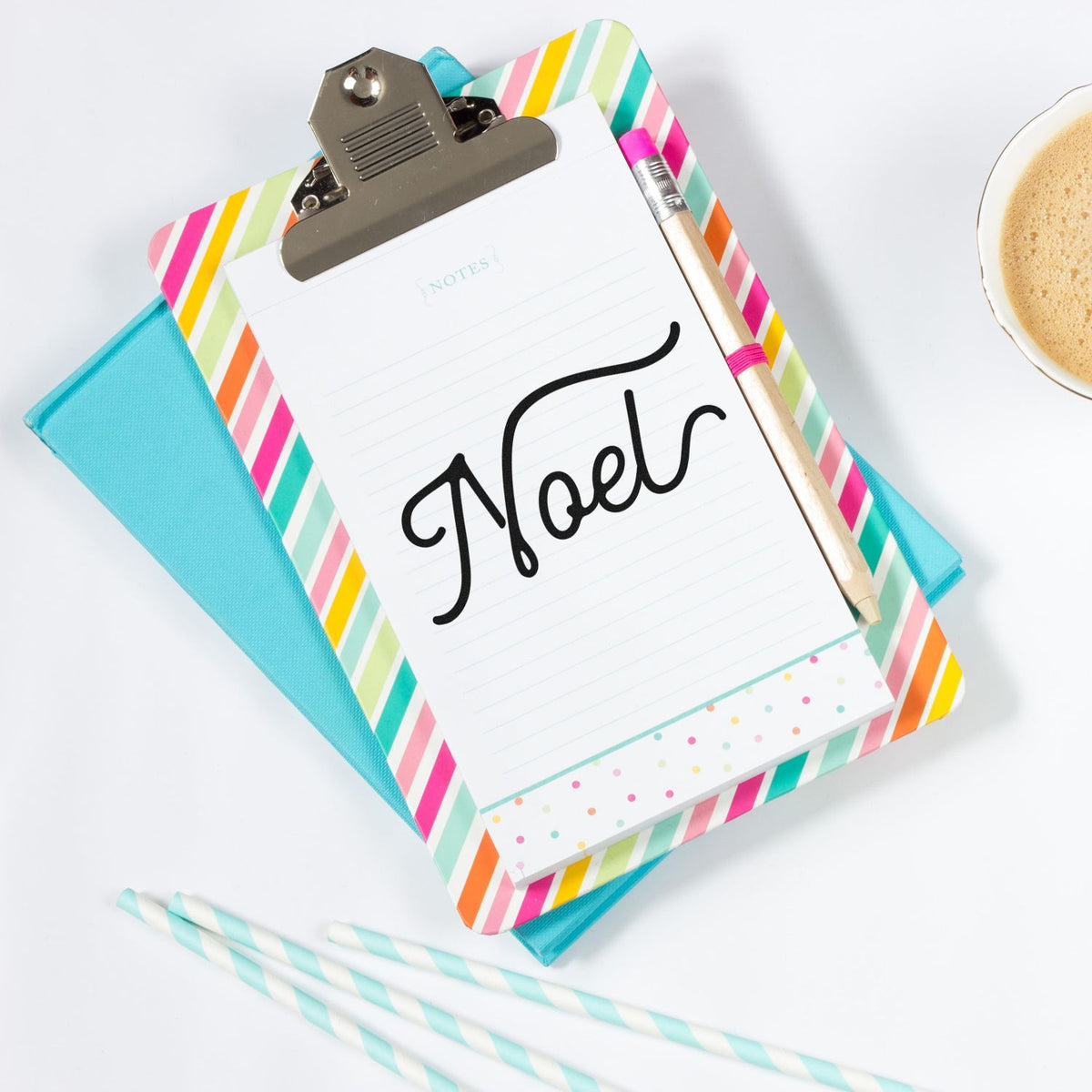 Colorful striped stamp and seal stationery set with notes pad, pen, turquoise notebook, and coffee cup.
