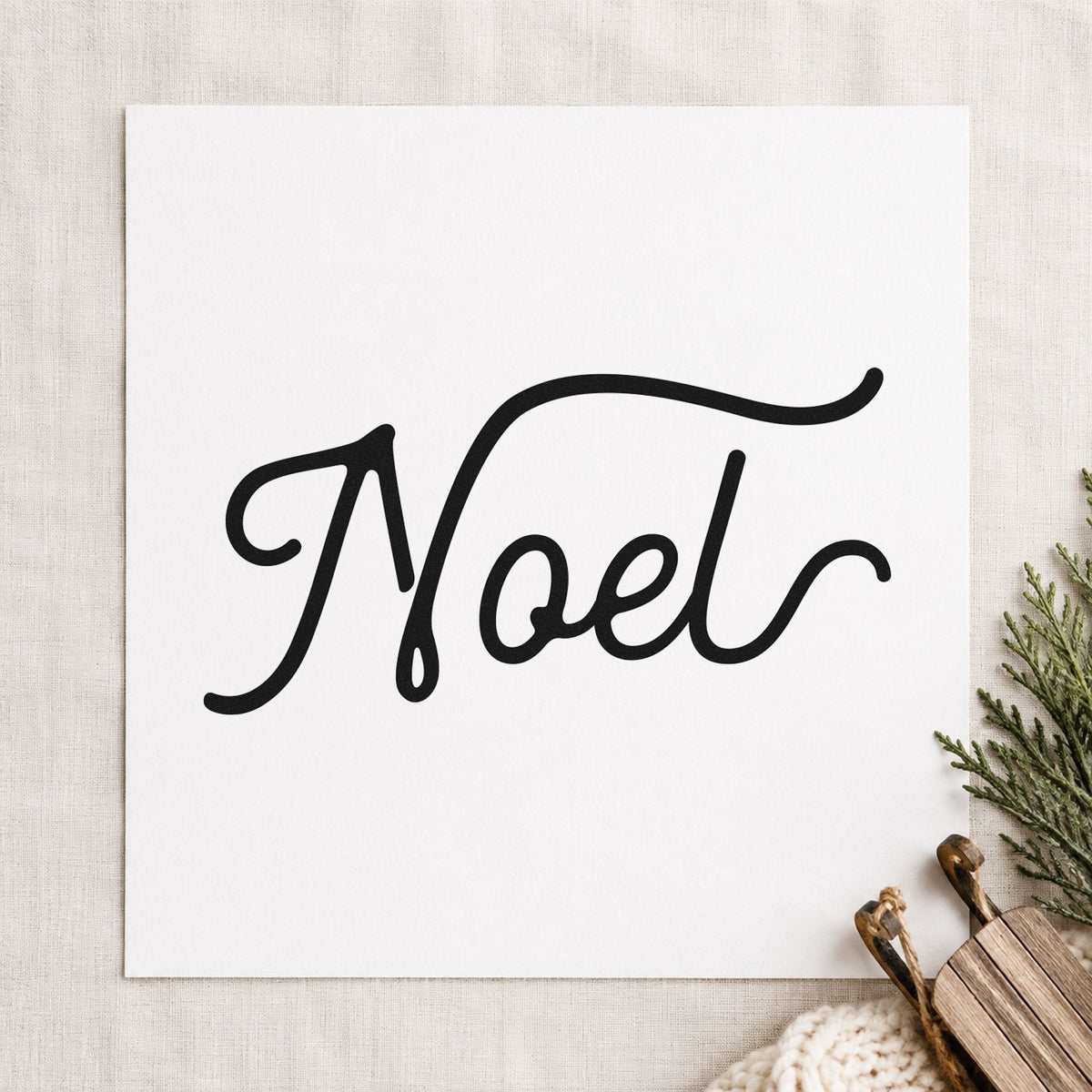 Noel Flowing Script craft stamp imprint in black ink on a handmade project, one idea being belly band tags.