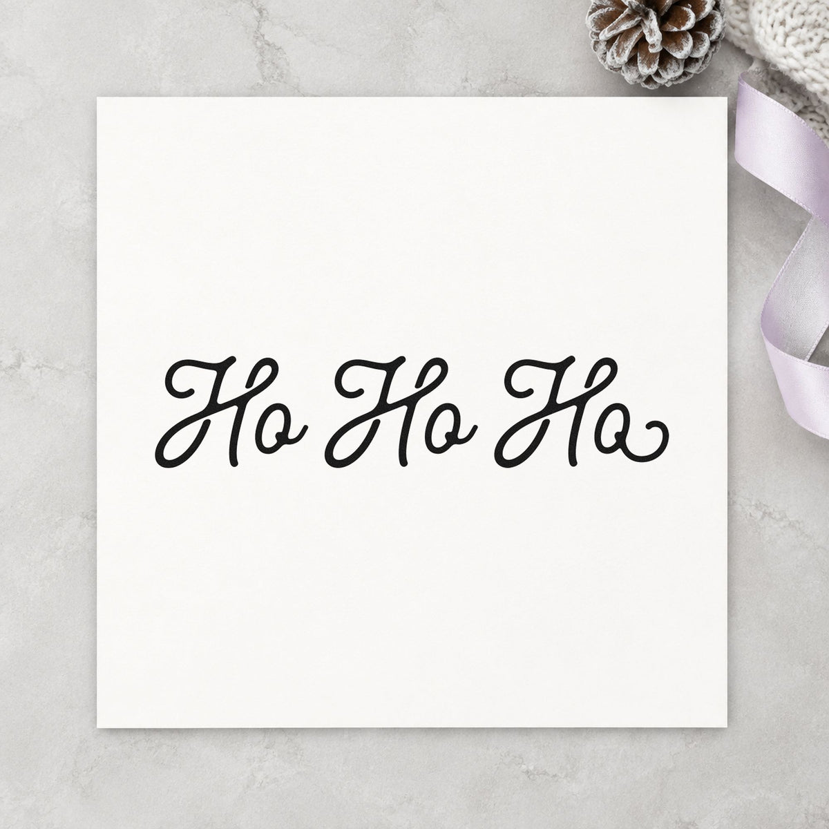 Ho Ho Ho Script craft stamp imprint in black ink on a handmade project, one idea being thin band gift tags.