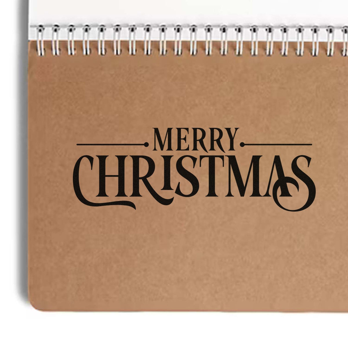 Brown kraft stamp and seal pad with black Merry Christmas lettering and white spiral binding.