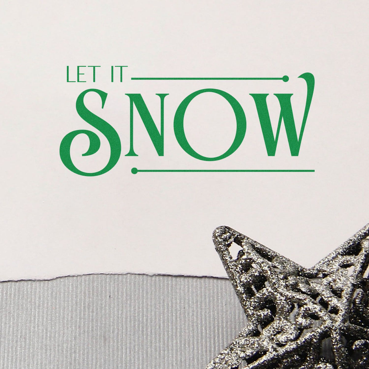 Holiday stamp and seal reading LET IT SNOW in green with a silver glitter star on white background.