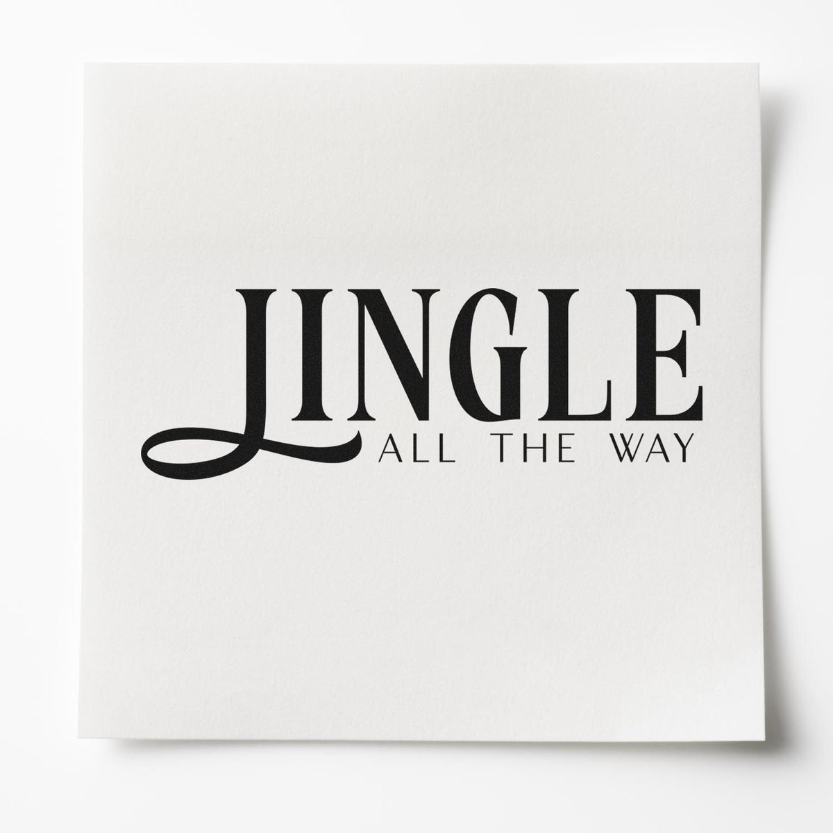 Black JINGLE ALL THE WAY stamp seal on white textured paper, featuring bold serif typography and a festive holiday design.