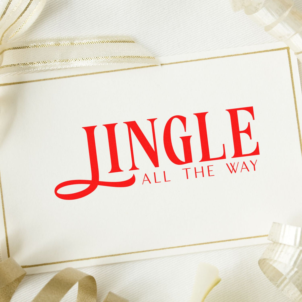 Red JINGLE ALL THE WAY stamp and seal on ivory card with gold border and sheer ribbon accents.