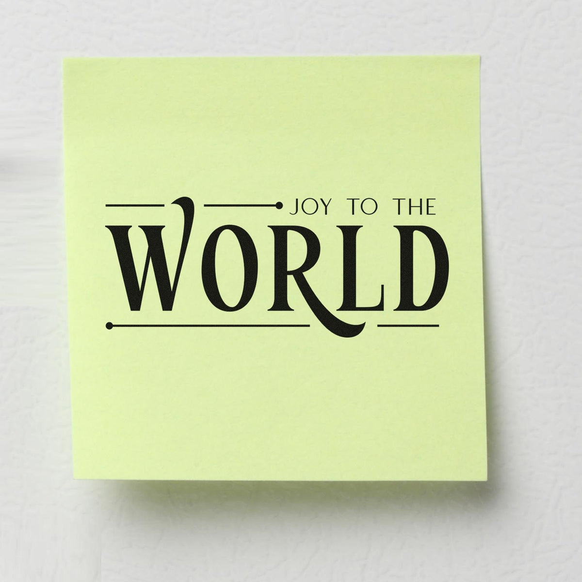 Pale yellow stamp seal with black JOY TO THE WORLD festive lettering and decorative lines.