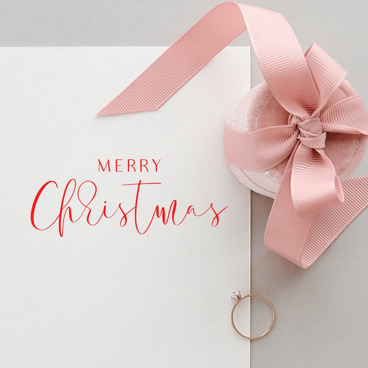White card with red Merry Christmas stamp, pink ribbon bow, and gold seal ring.