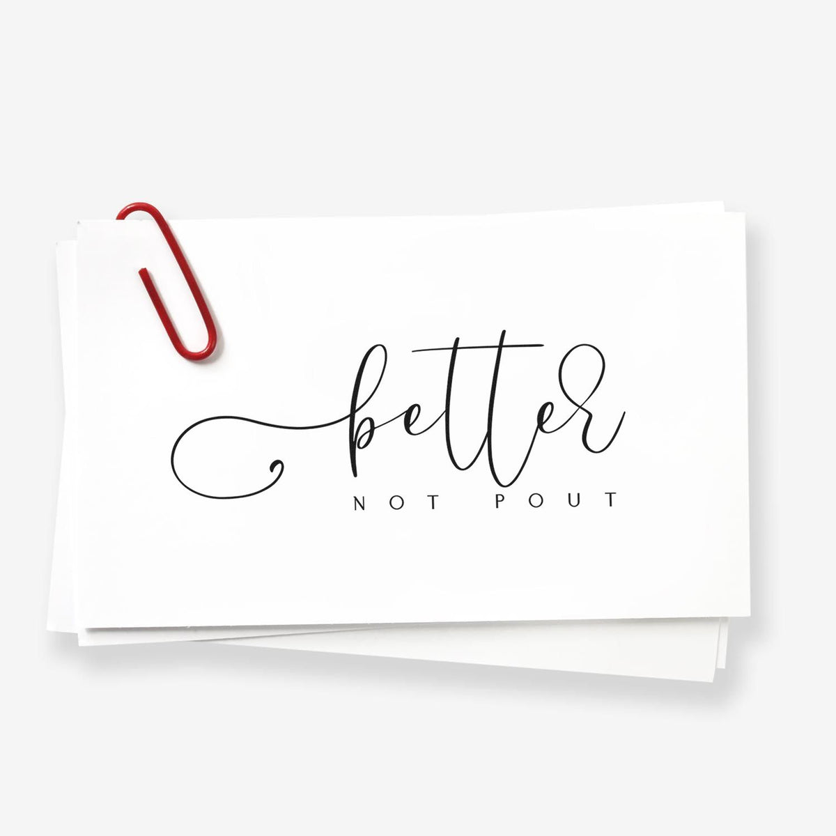 White stamp and seal card with black better not pout lettering and a red paperclip on stacked white paper.