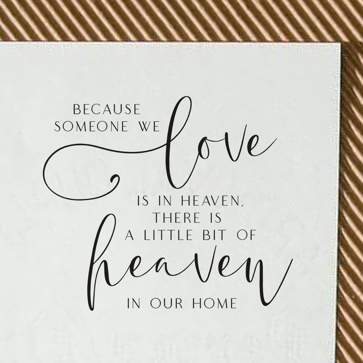White memorial stamp and seal with black quote text and script words love and heaven on a tan striped background.