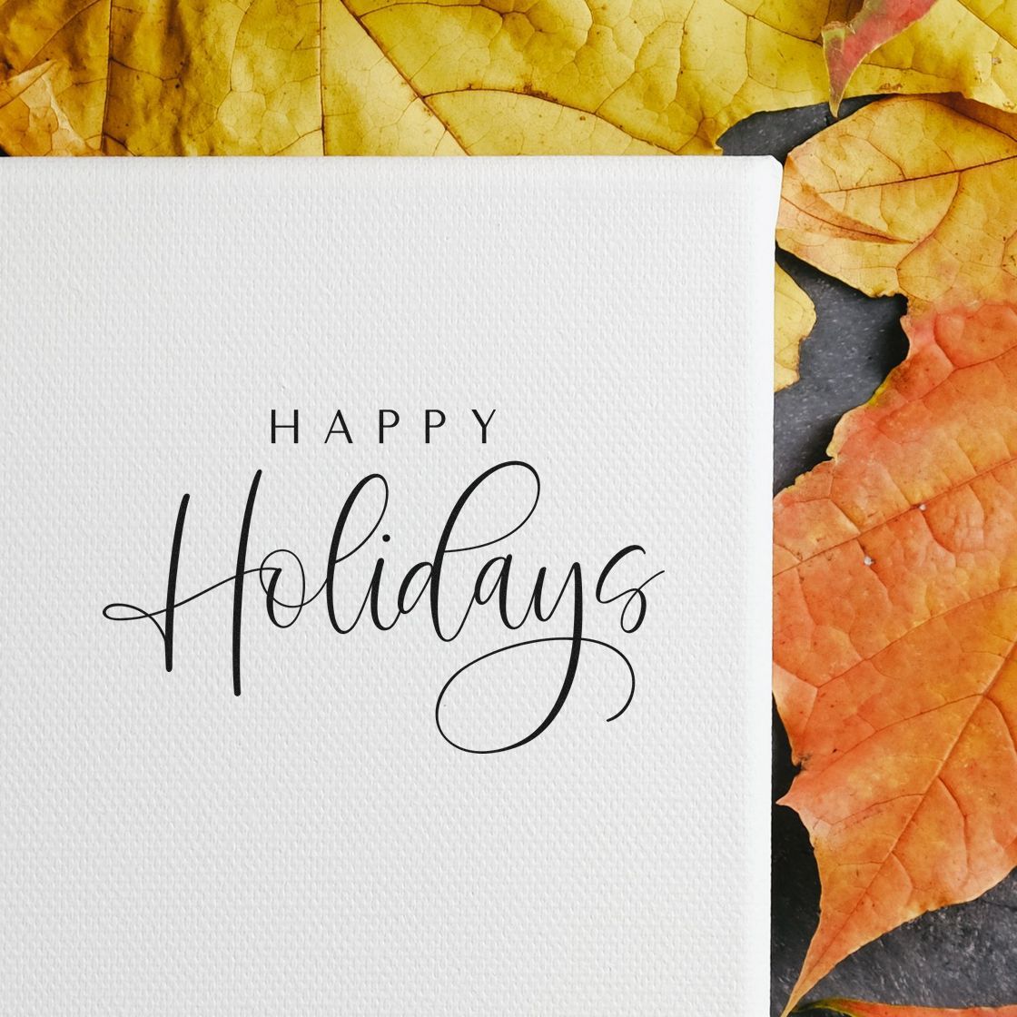 Holiday stamp and seal design on white textured card with black Happy Holidays script, framed by yellow and orange leaves.