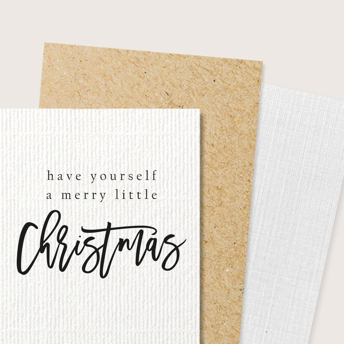 Christmas stamp and seal samples on textured white and kraft paper, featuring black have yourself a merry little Christmas text.