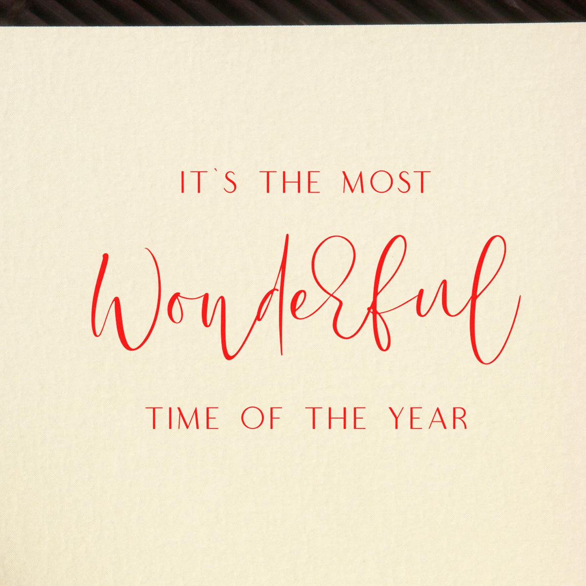 Cream paper stamp and seal with red lettering reading Its the most wonderful time of the year for holiday packaging.