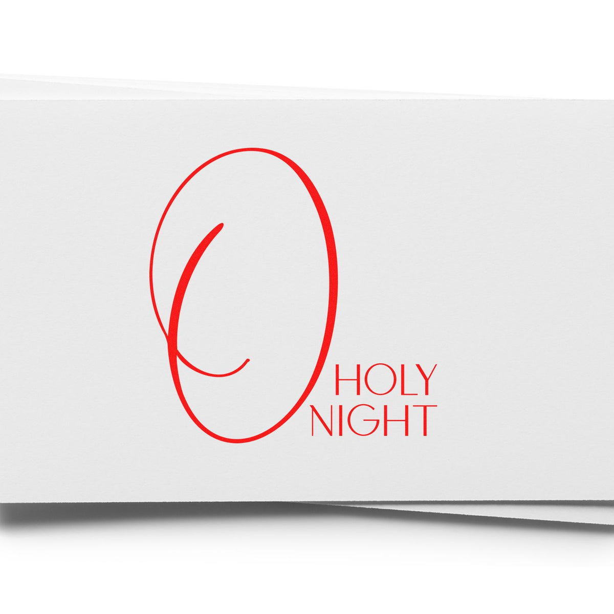 Red holiday stamp seal reading HOLY NIGHT on white folded paper.