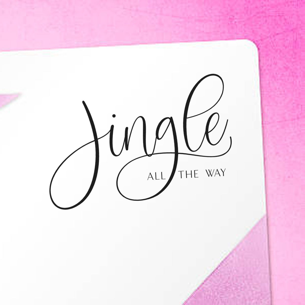 Pink and white stamp seal product featuring black Jingle all the way script on a white card.