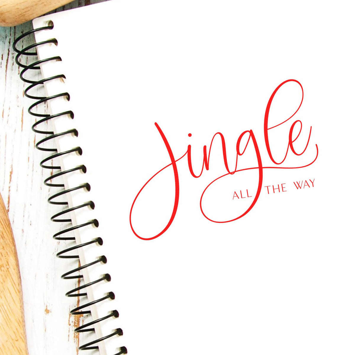 Red Single all the way stamp and seal on white, beside a black spiral notebook edge.