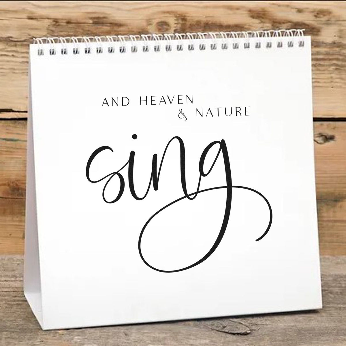 White stamp and seal paper bag with black And Heaven & Nature Sing script on rustic wood background