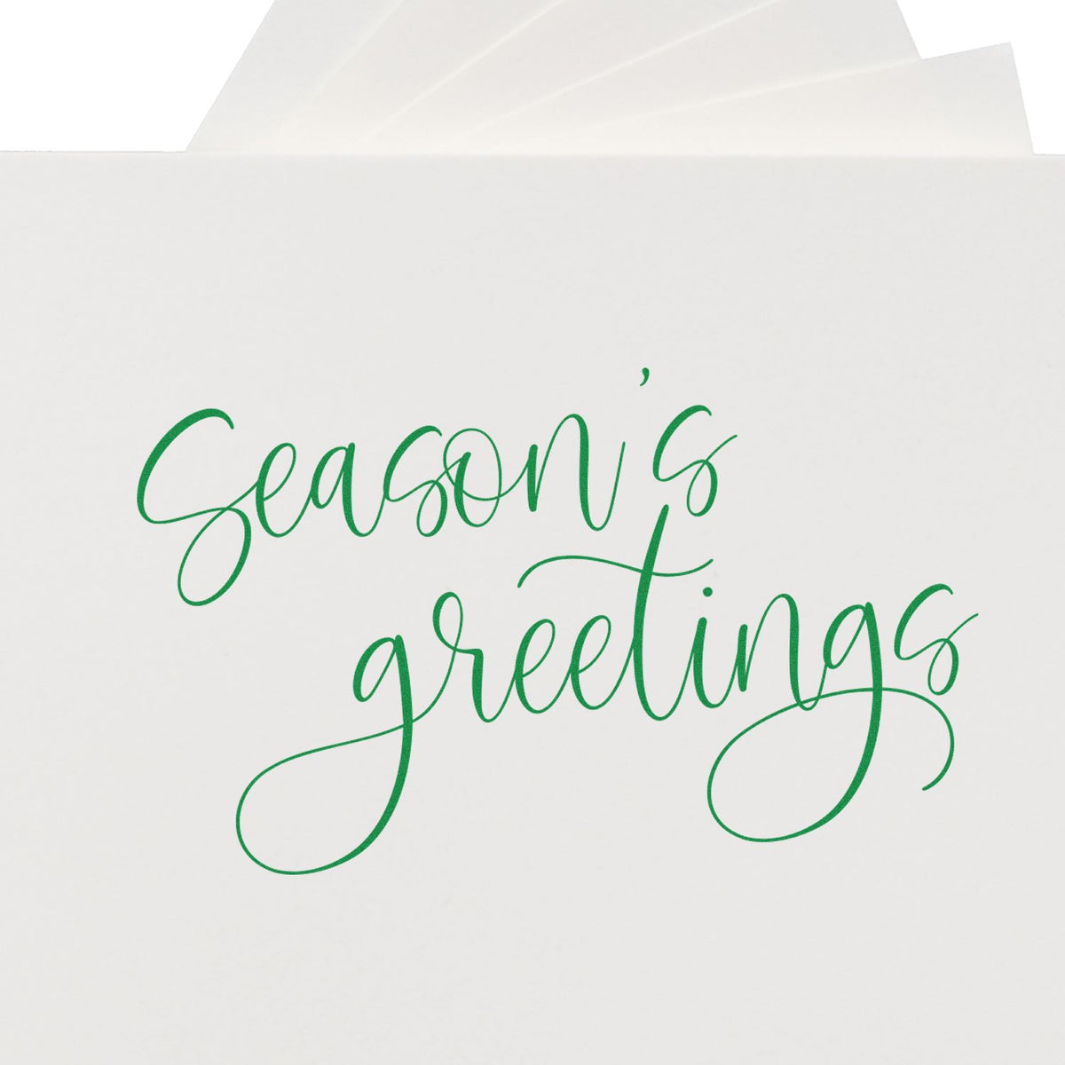Green script Seasons Greetings holiday stamp on a white envelope, with matching green seal accents.