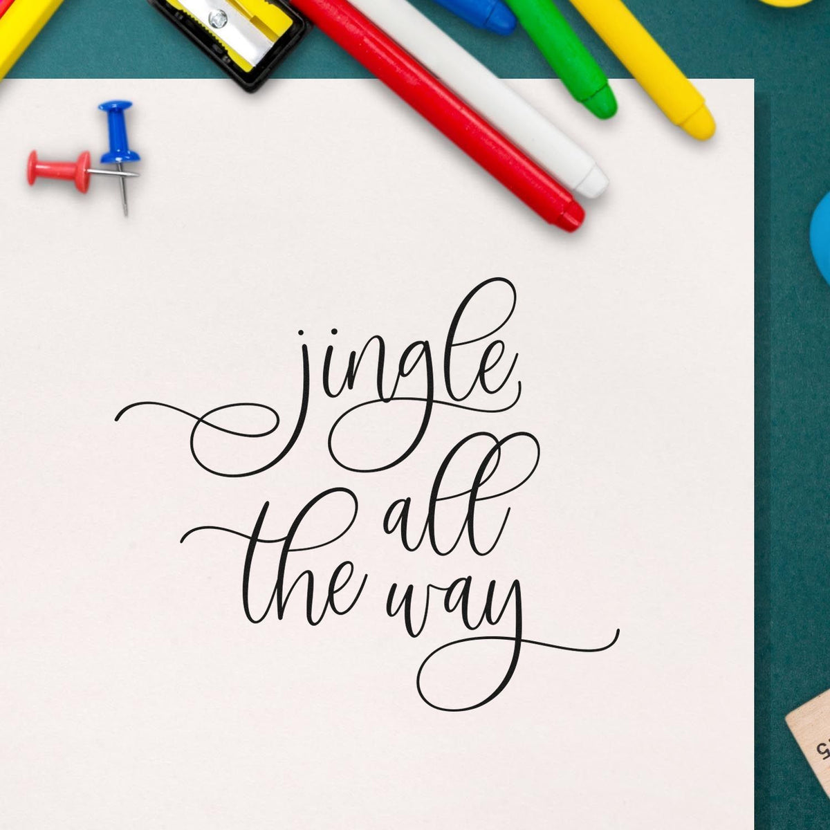 Holiday stamp and seal with black jingle all the way script on white, framed by red, blue, green and yellow tools