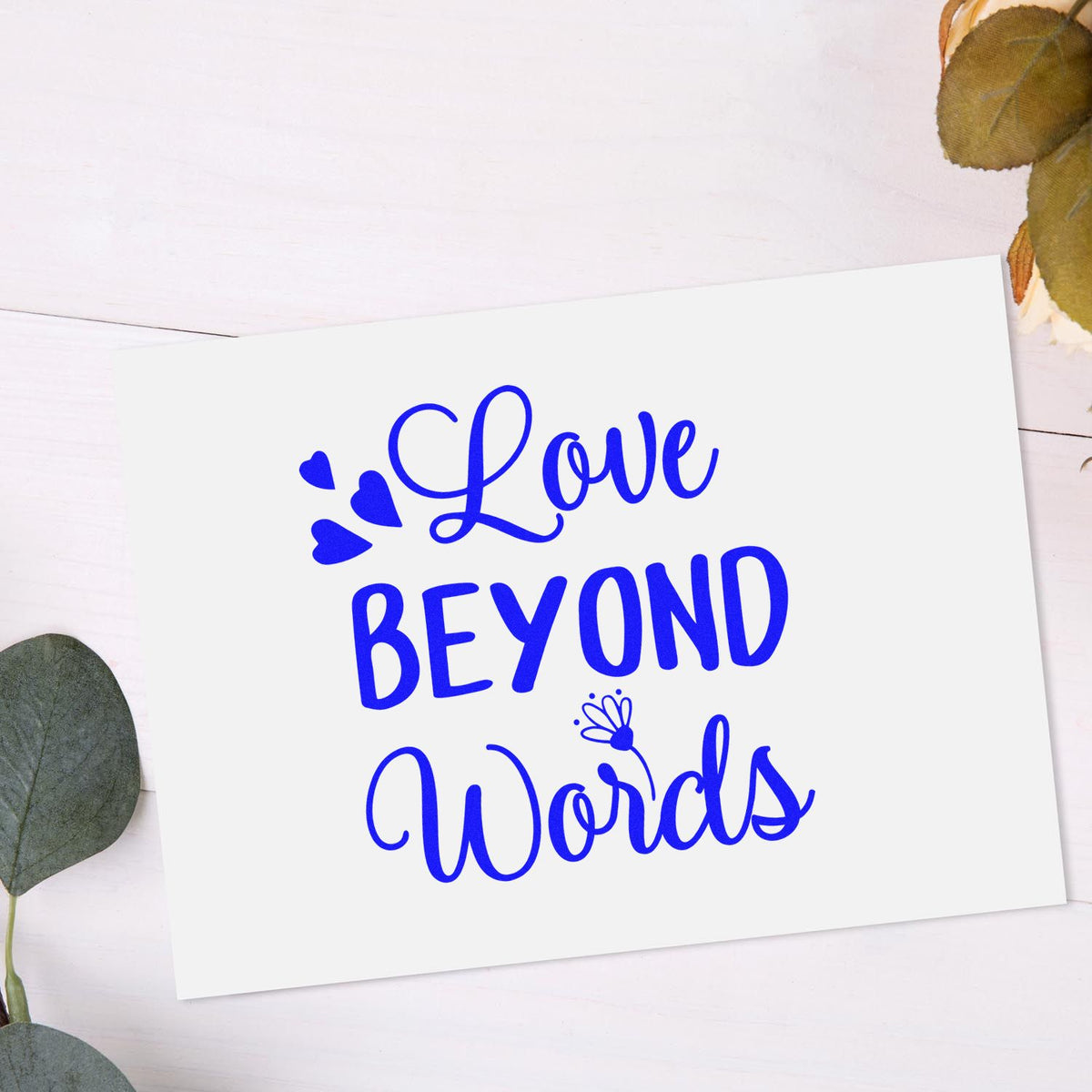 Blue Love Beyond Words stamp on white card with heart accents and eucalyptus leaves.