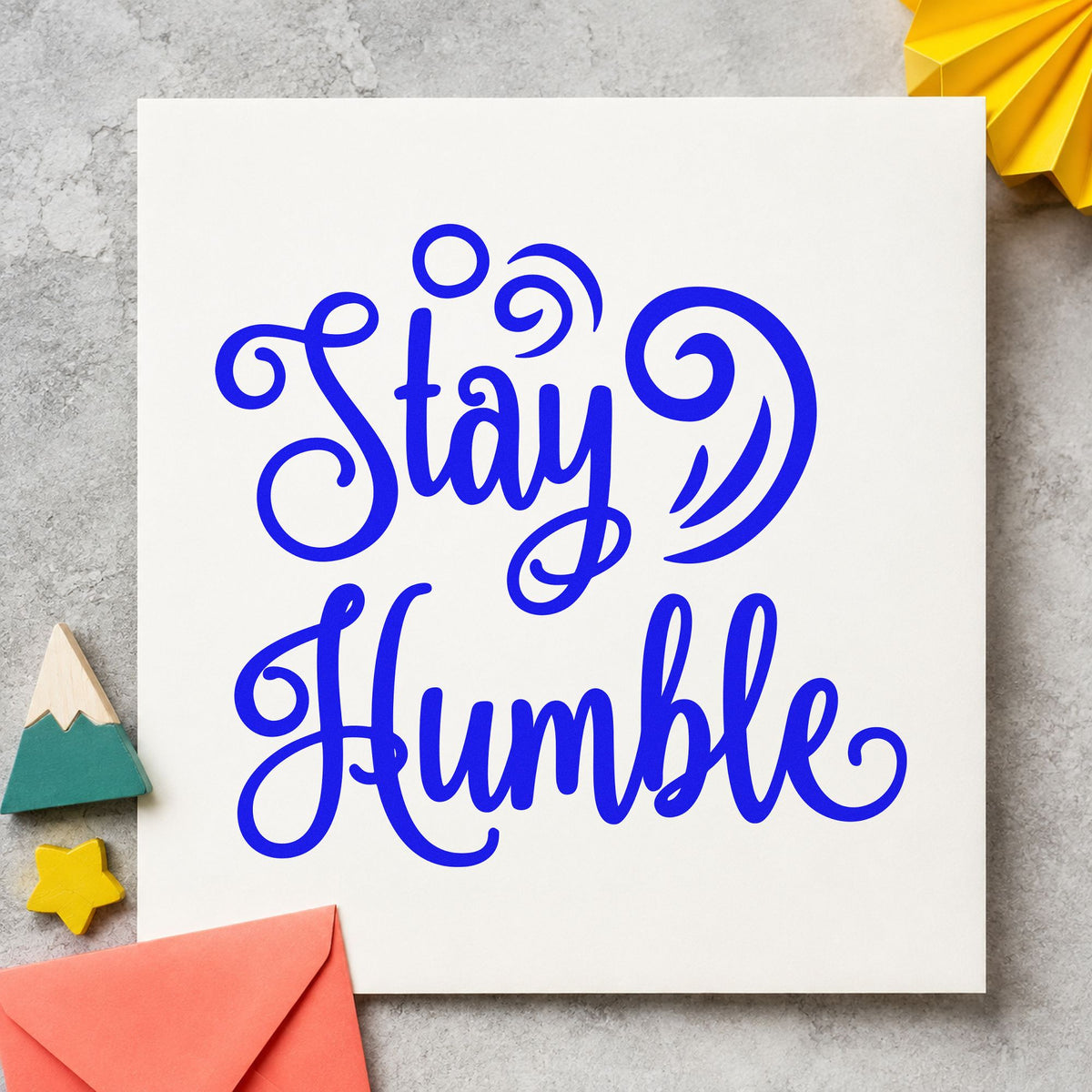 Stay Humble Decorative Swirls craft stamp in blue ink on cardstock, an easy option for work shirt printing.