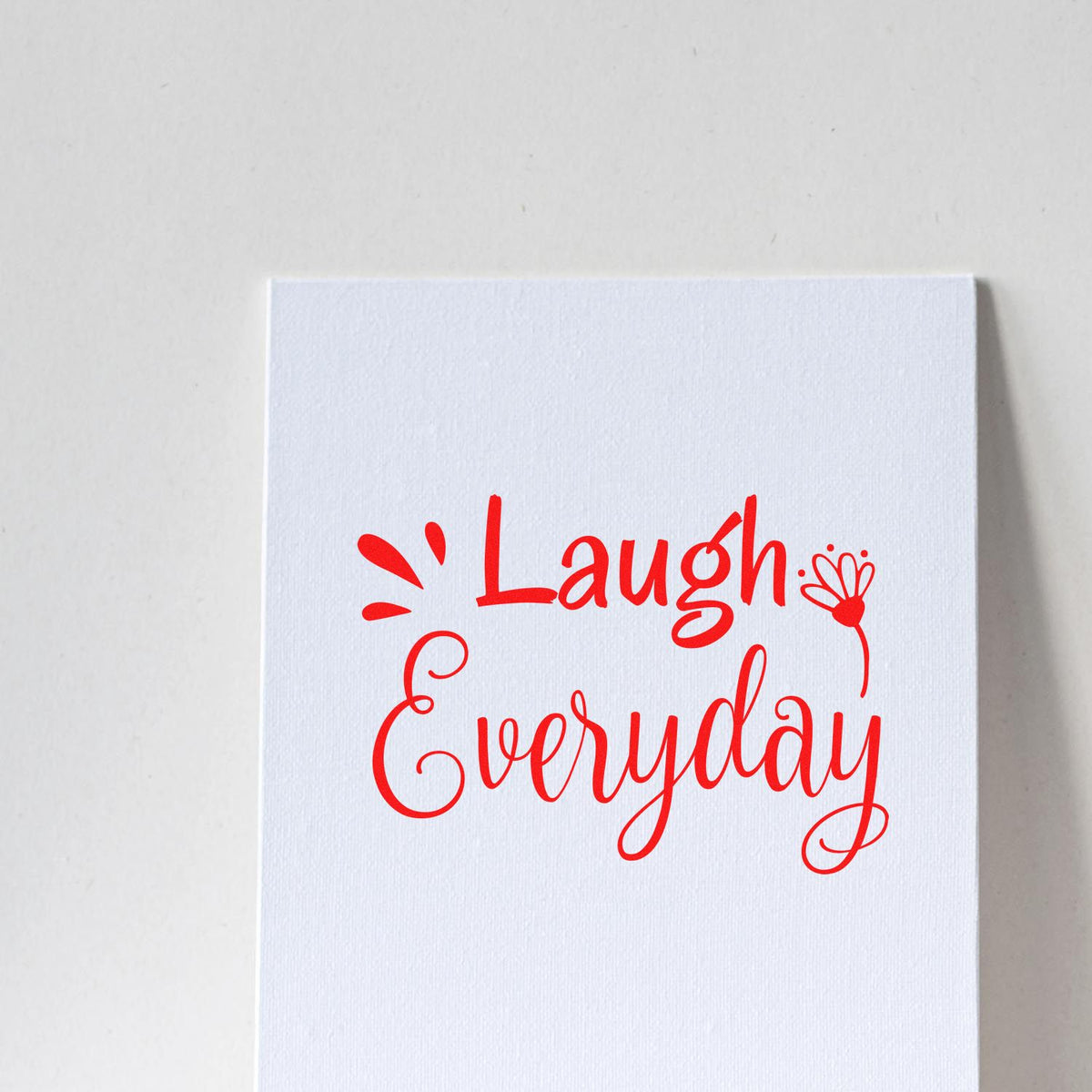 Red Laugh Everyday decorative stamp design on a white textured card for seal products.
