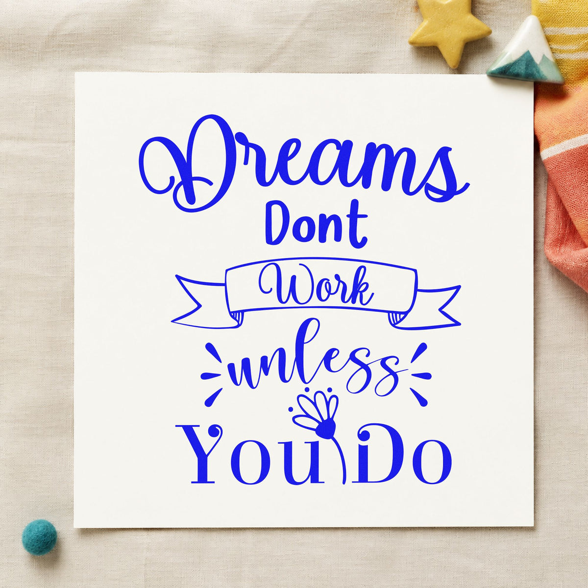 Dreams Don't Work Unless You Do craft stamp imprinted in blue ink on paper, a design suited to framed front counter.