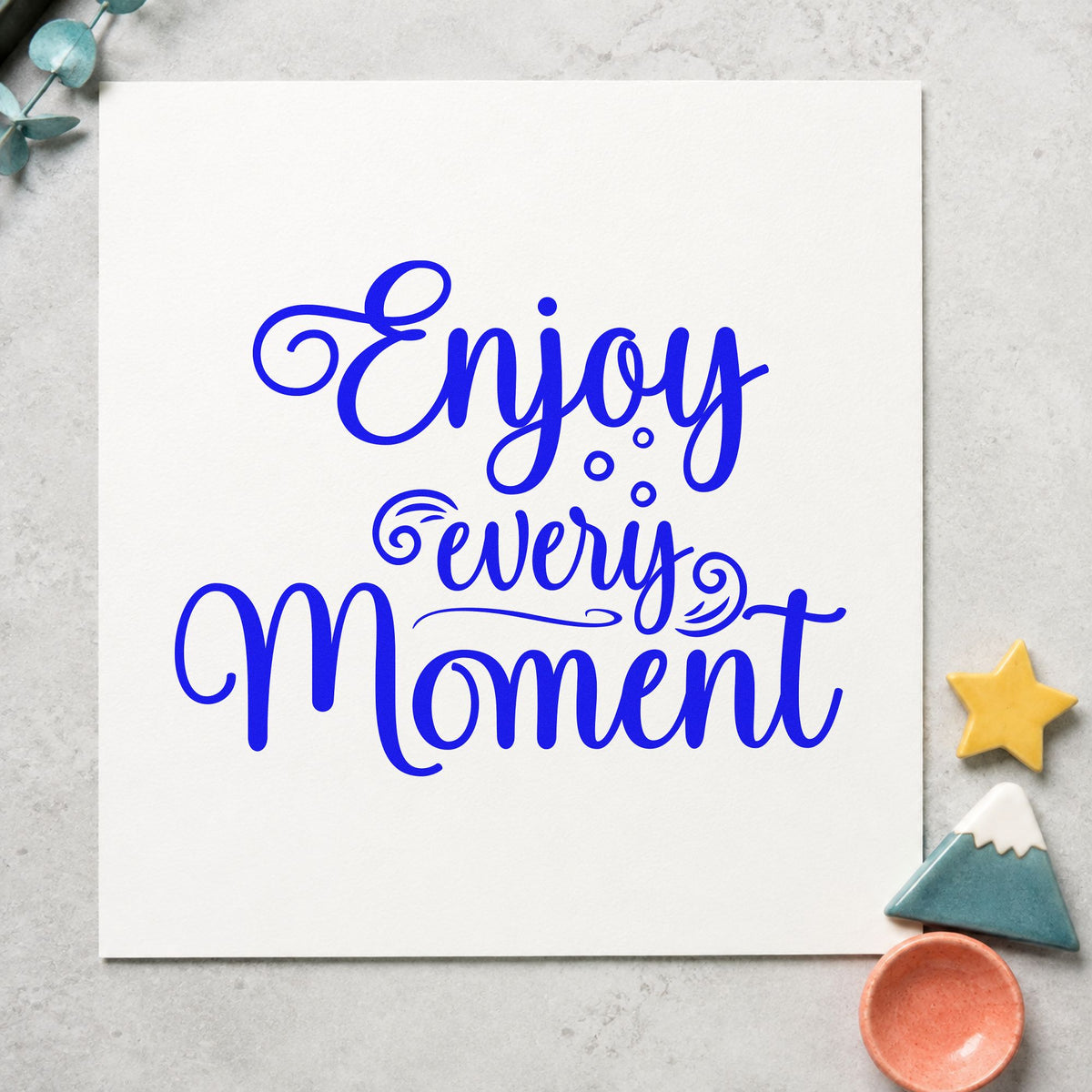 Enjoy Every Moment Flourishes craft stamp imprinted in blue ink on paper, a design suited to framed welcome easel.