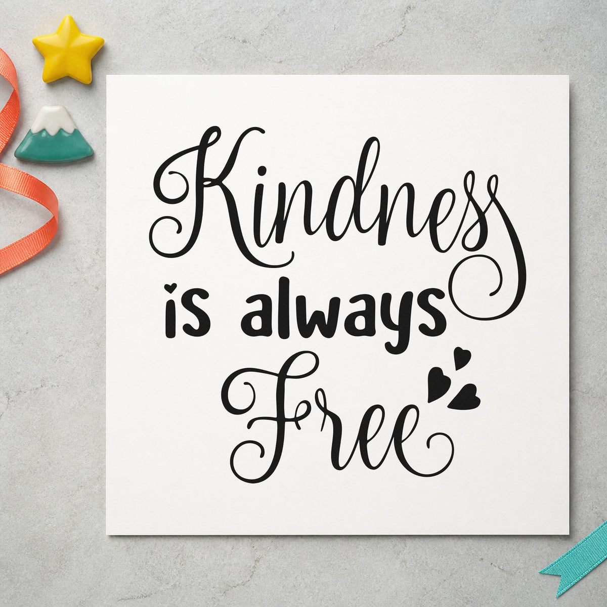 Kindness Is Always Free craft stamp imprint in black ink on a handmade project, one idea being donation box tags.