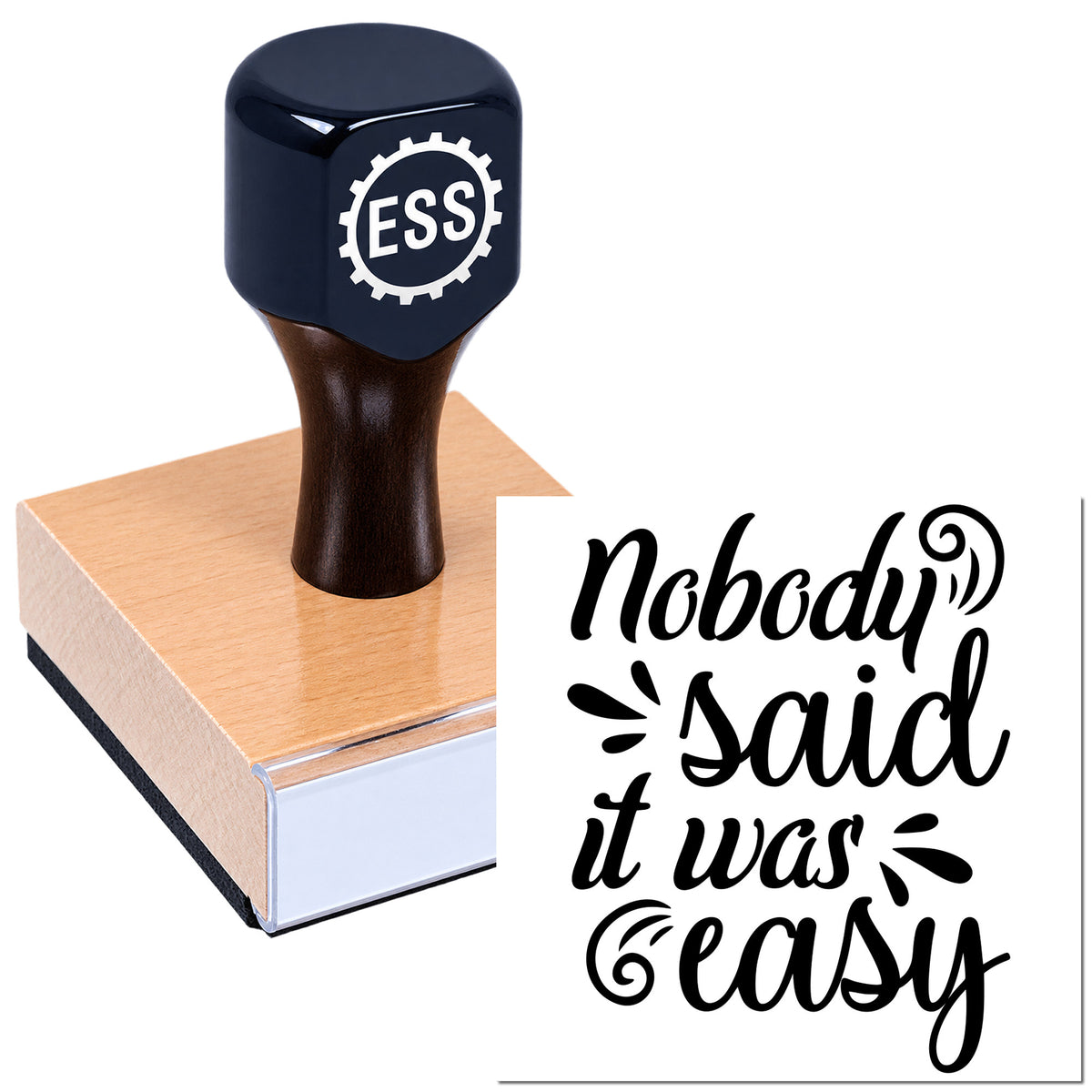 Dark blue ESS rubber stamp on a wooden block, with black "Nobody said it was easy" seal design.