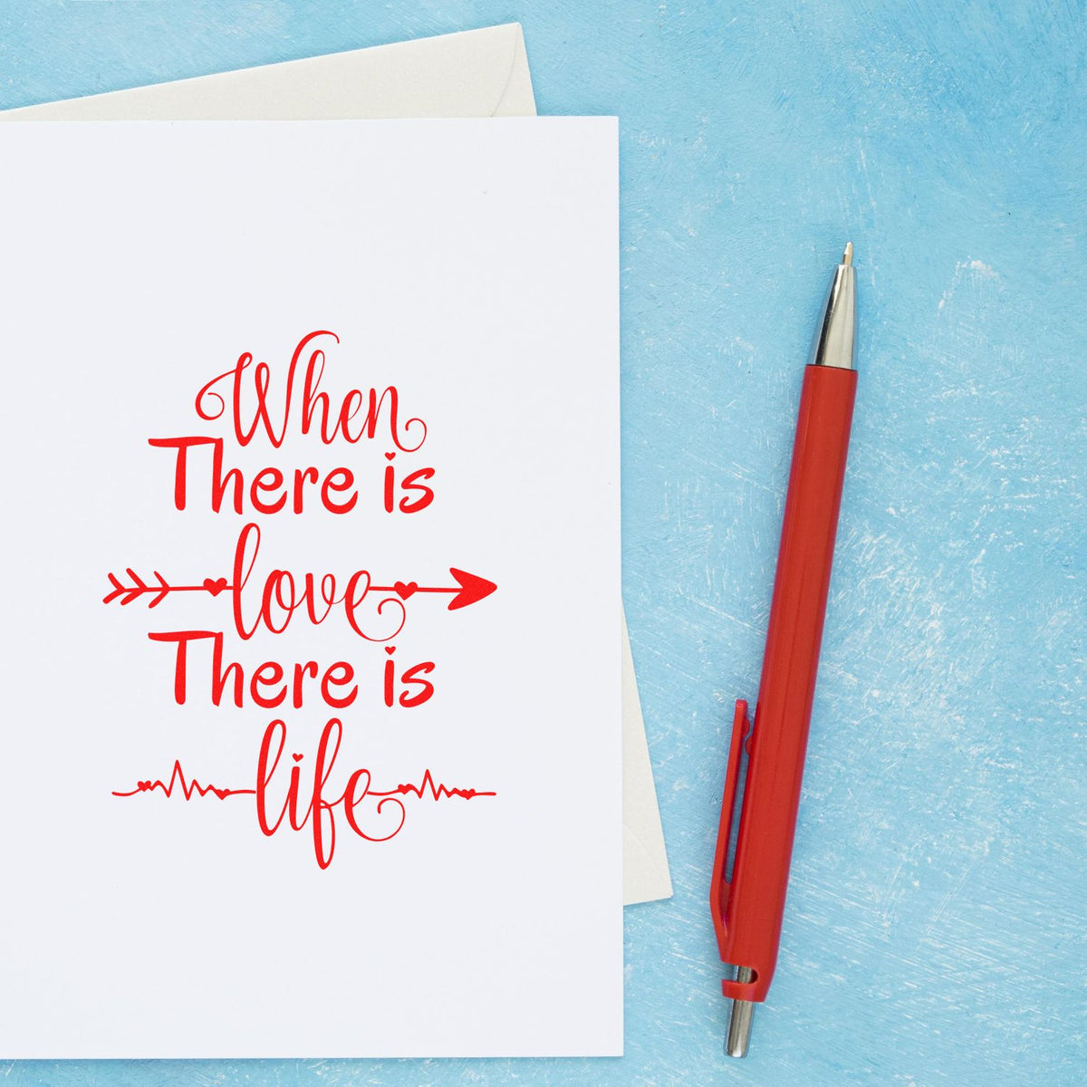 Custom red quote stamp on white card beside a red pen, set against a textured blue background.