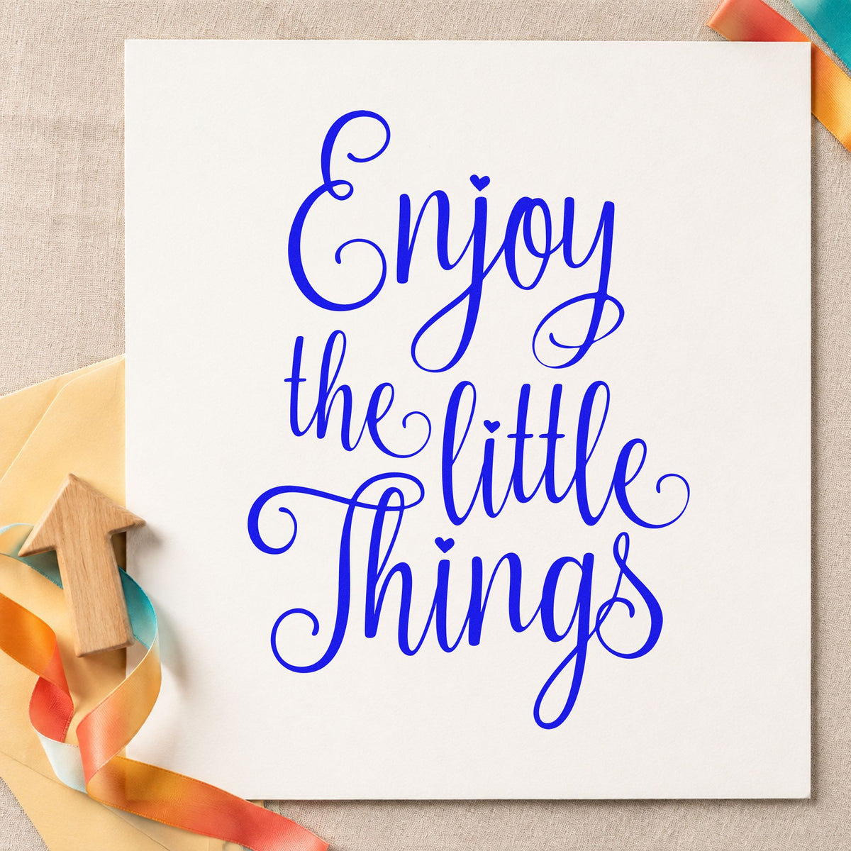 Enjoy The Little Things craft stamp imprinted in blue ink on paper, a design suited to framed kitchen shelf.