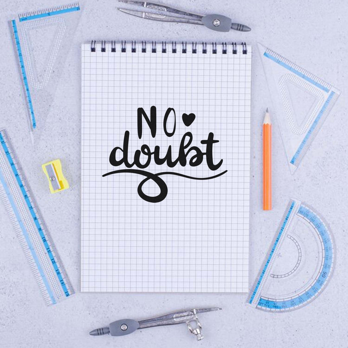 Black No doubt stamp on grid notebook, framed by blue drafting rulers, compass, pencil, and seal tools.