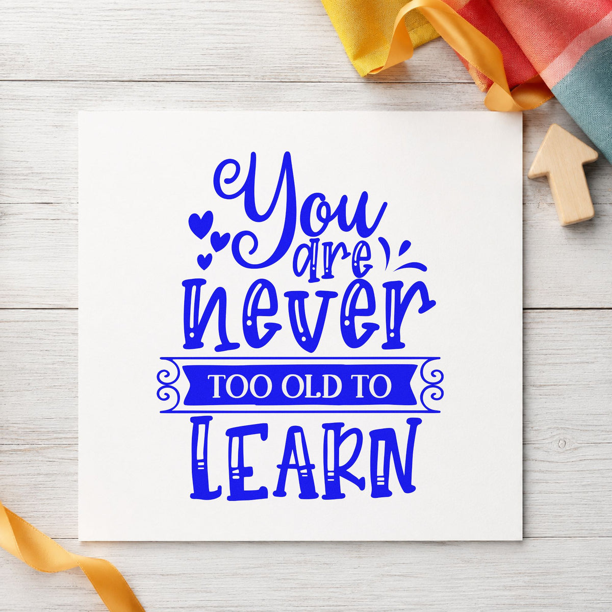 Never Too Old To Learn craft stamp in blue ink on cardstock, an easy option for studio apron printing.