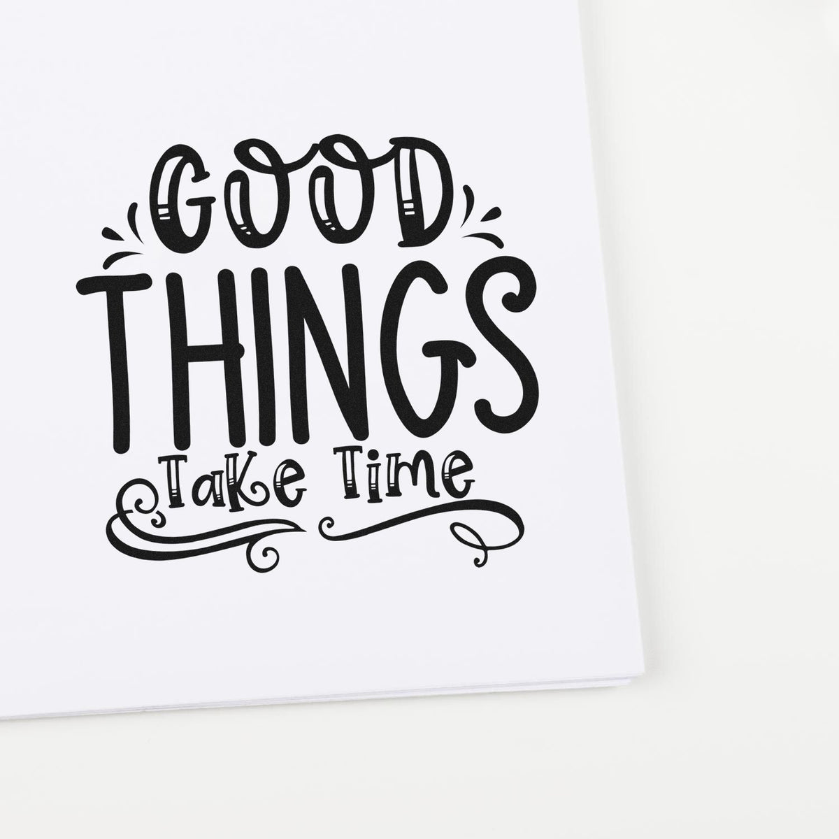 Black decorative stamp-and-seal design reading Good Things Take Time on white paper with ornate swirls.