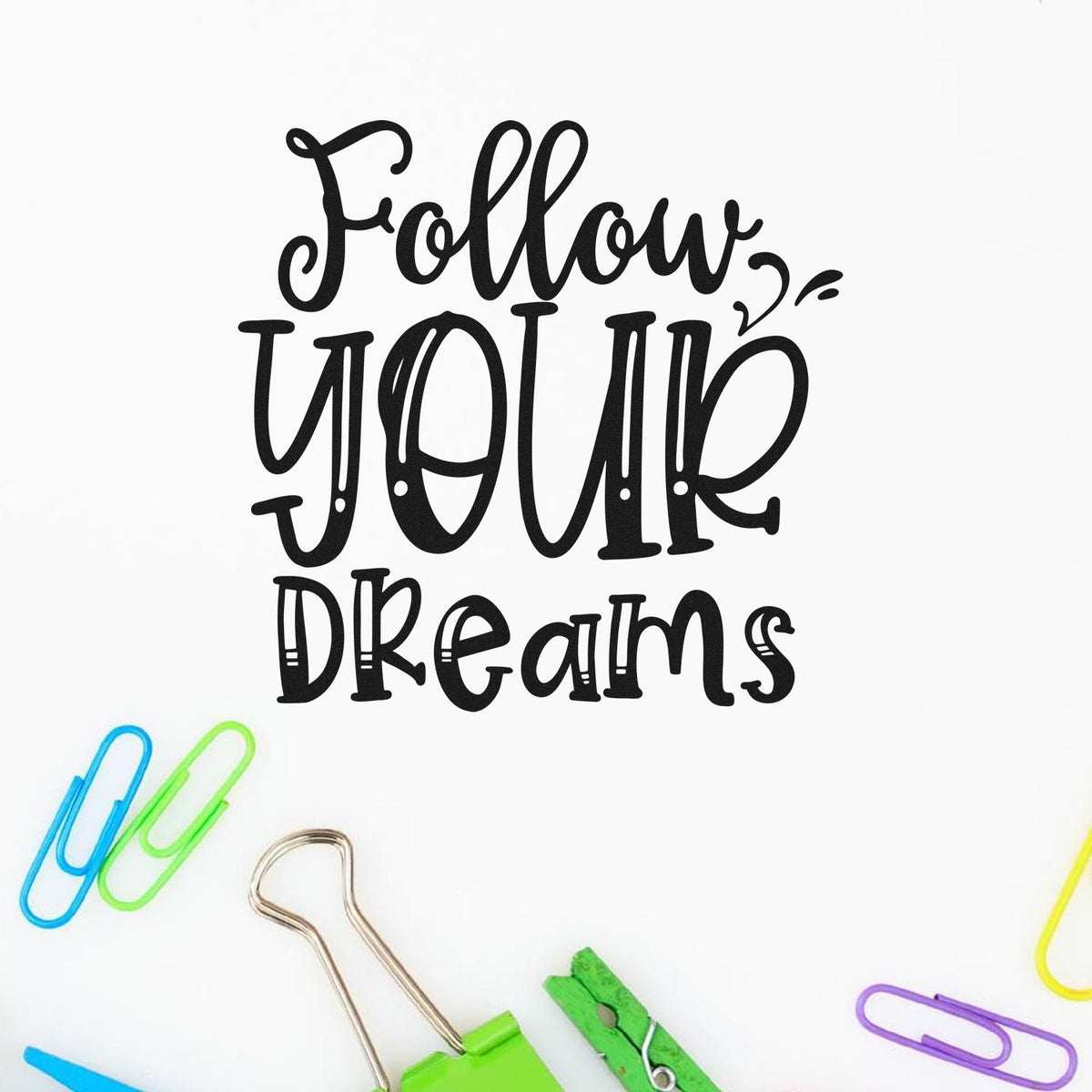 Black Follow your dreams stamp design with colorful paper clips and binder clips on a white background.