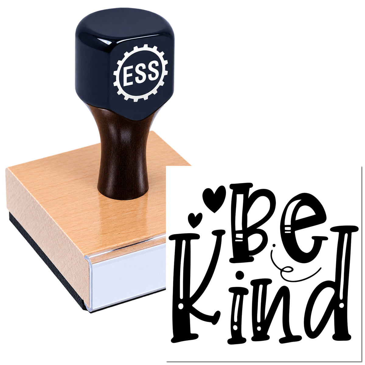 Navy self-inking stamp on a peach wood block, showing a black "Be Kind" seal with heart accents.