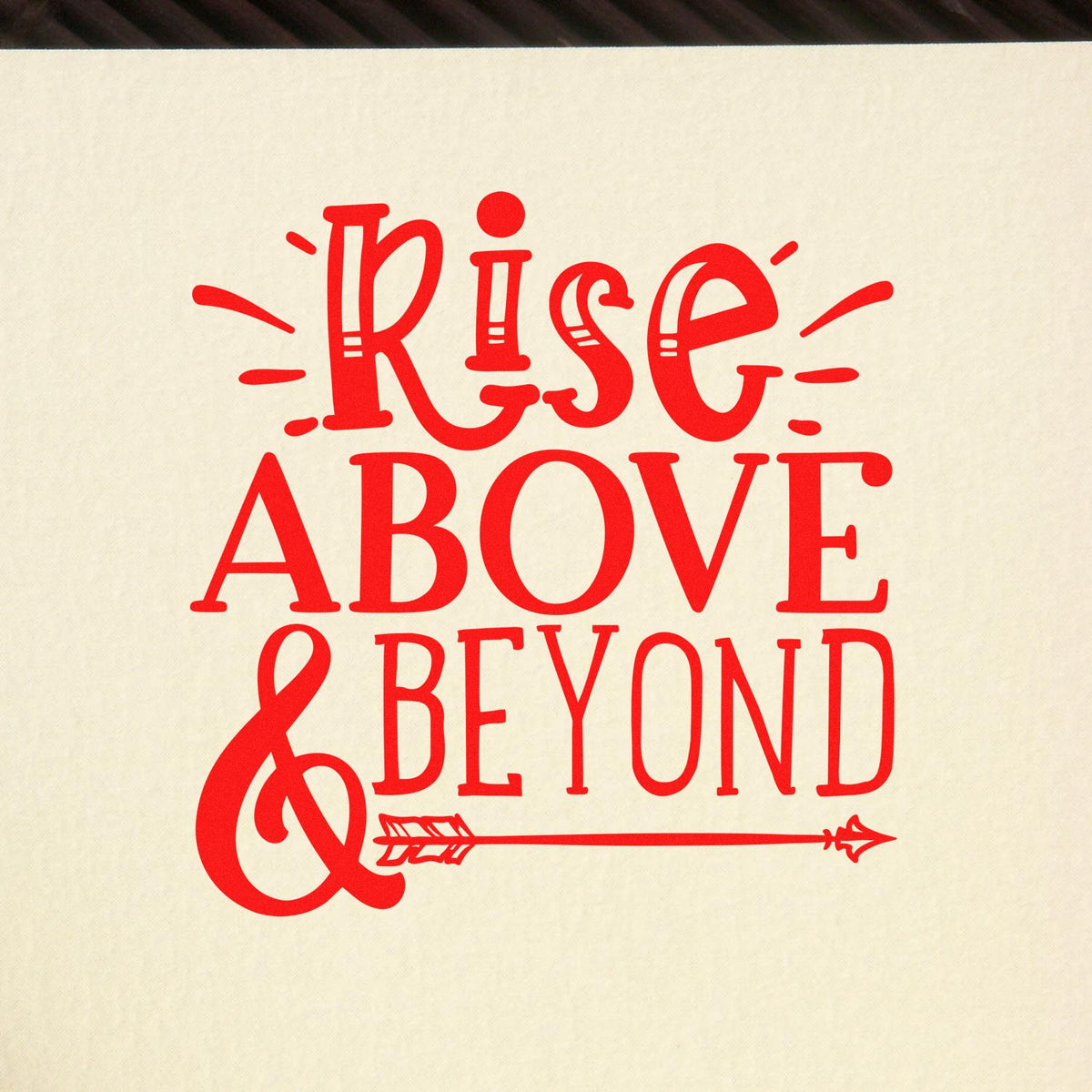 Red Rise Above & Beyond decorative stamp and seal design on cream background with arrow and ampersand.