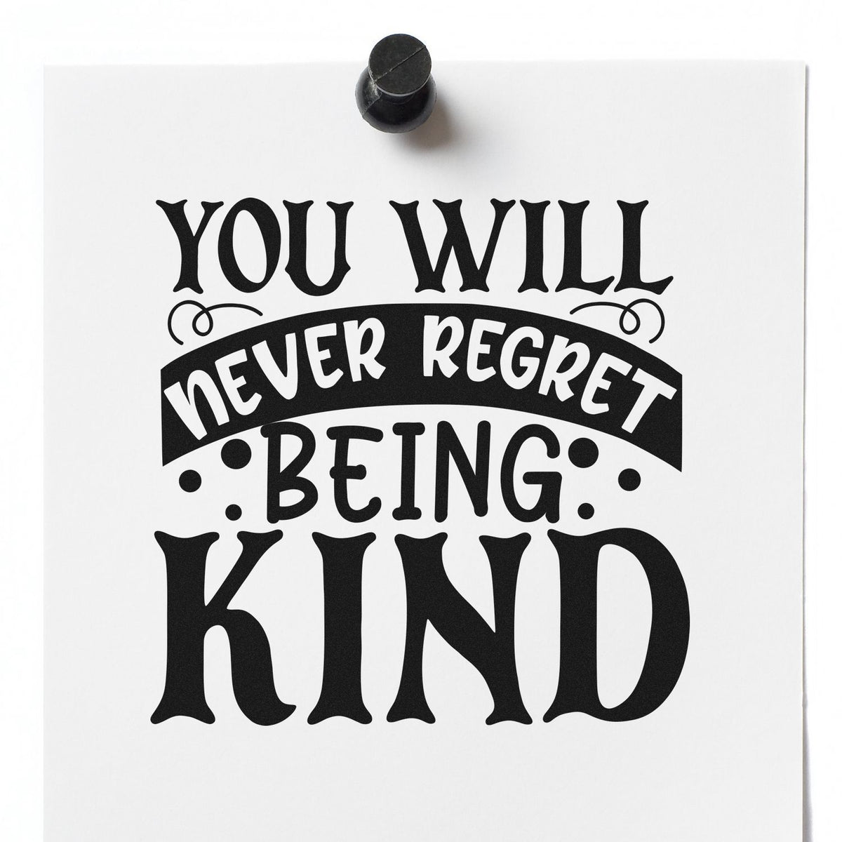 Black rubber stamp seal on white paper with quote: You will never regret being kind.