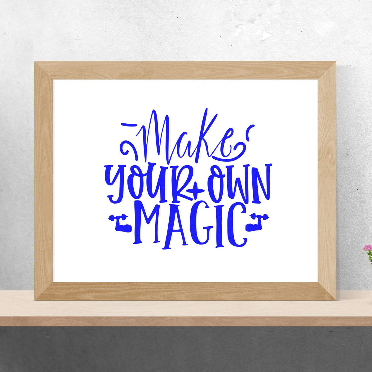 Blue Make Your Own Magic stamp and seal design in a light wood frame on a white background.
