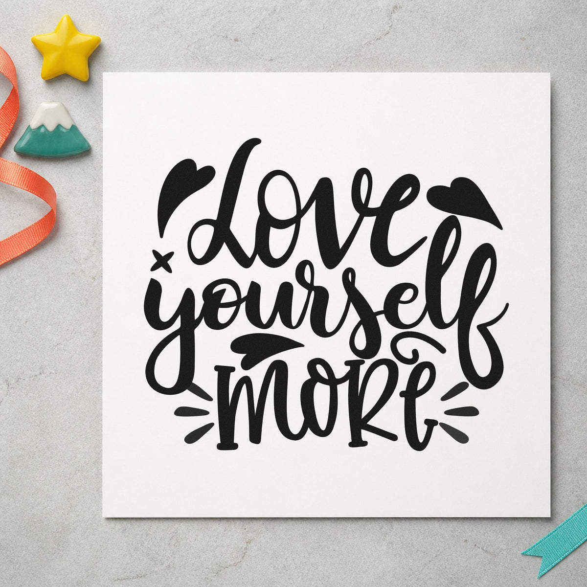 Love Yourself More Hearts craft stamp imprint in black ink on a handmade project, one idea being mat strap gift tags.