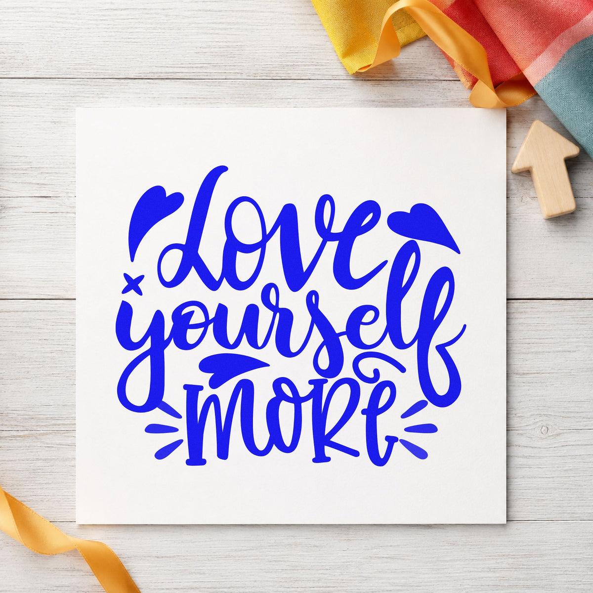 Love Yourself More Hearts craft stamp imprinted in blue ink on paper, a design suited to framed studio entry.